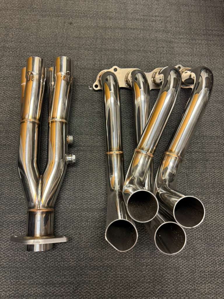 JackSpania Racing K20 K24 exhaust header with 2-bolt 4-2-1 Tri-Y design for EK, EG, DC2 Civic models, showing polished metal pipes.